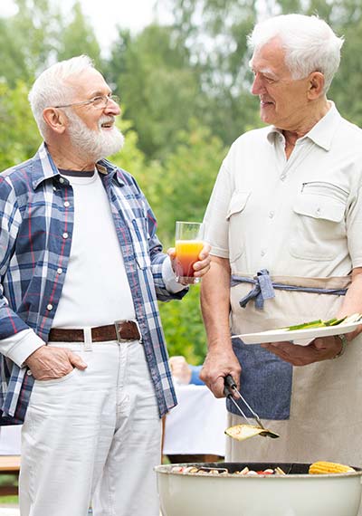Senior friends talking around the barbecue