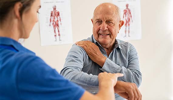 Elderly gentleman working through physiotherapy session with therapist